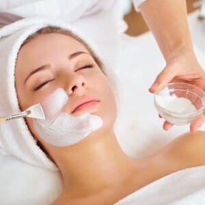 Woman receiving facial beauty treatment.