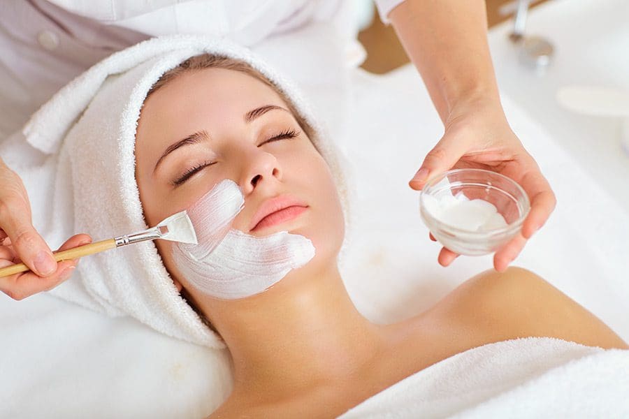 Woman receiving facial beauty treatment.