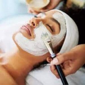 a woman getting a facial mask.