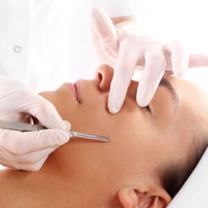 a woman getting a dermaplaning treatment on the face